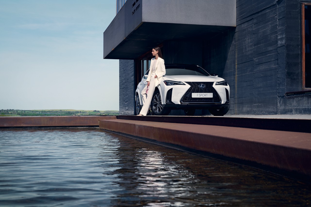 Nainen nojaa Lexus UX -malliin