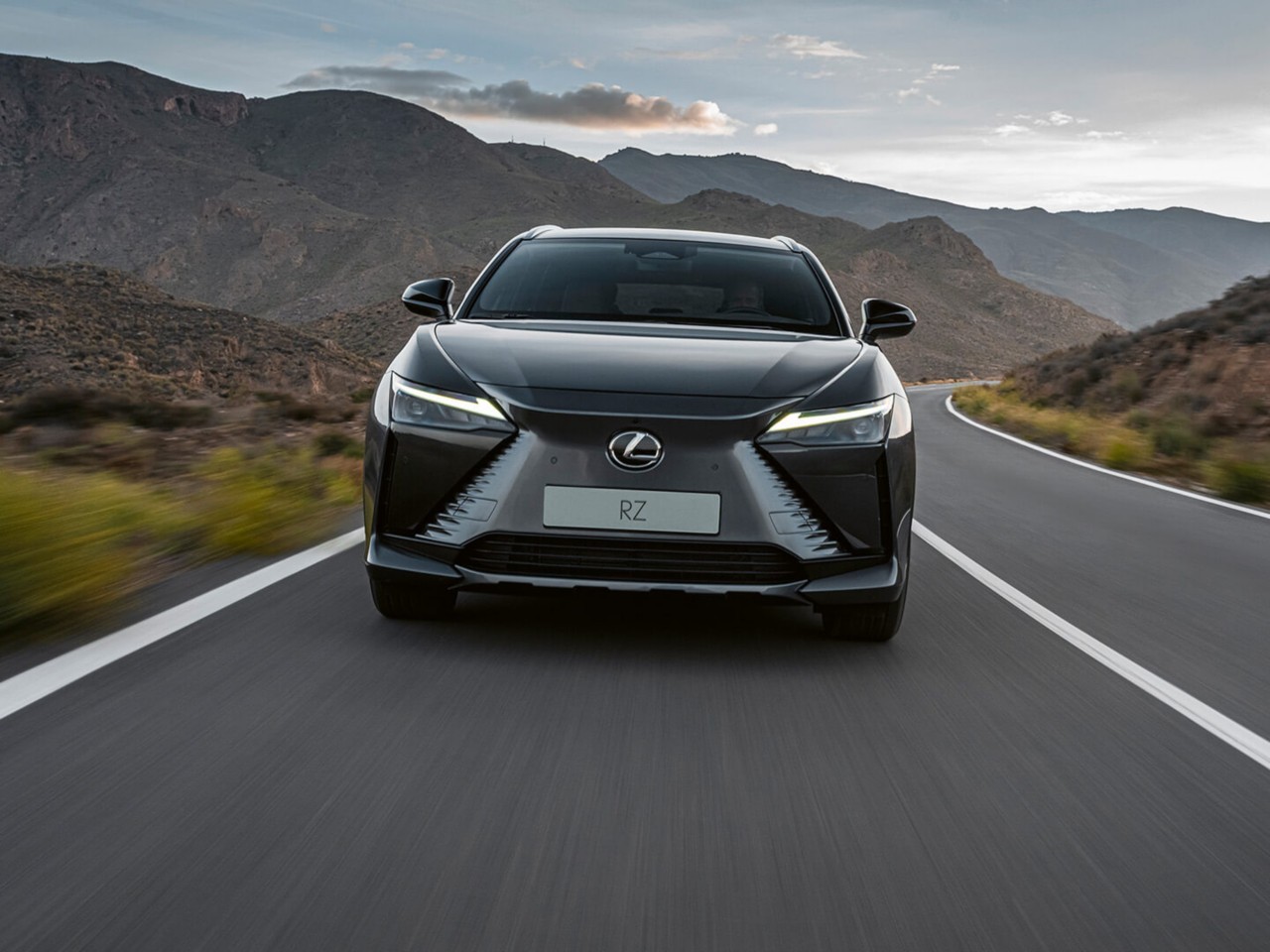 Front view of a Lexus RZ driving in a rural environment 
